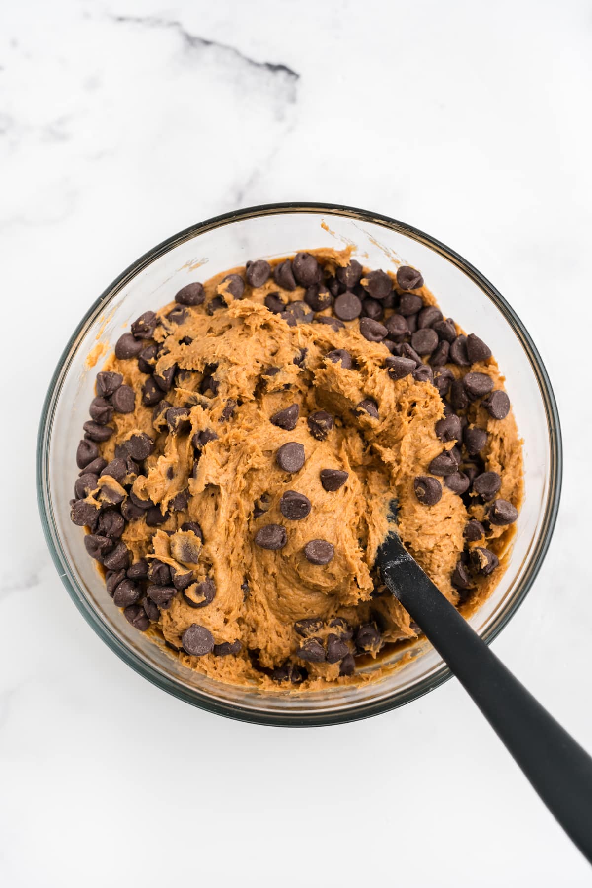 Chocolate chips being mixed into pumpkin cookie batter