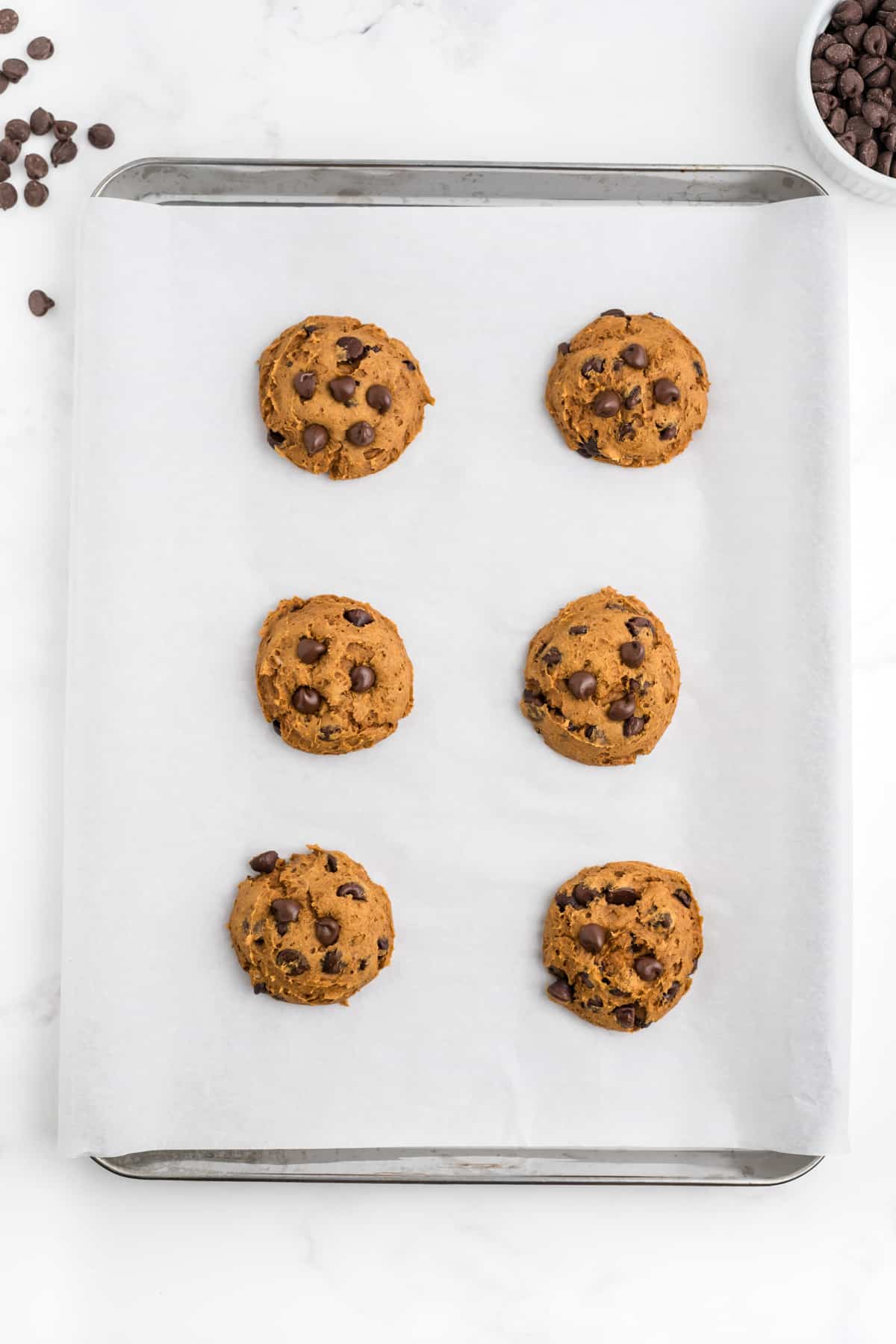 pumpkin cookies on a baking sheet after baking