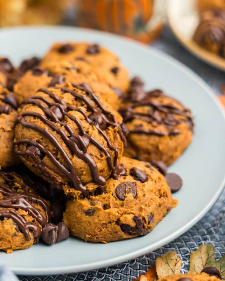 3 ingredient pumpkin cookies on a plate with melted chocolate drizzle.