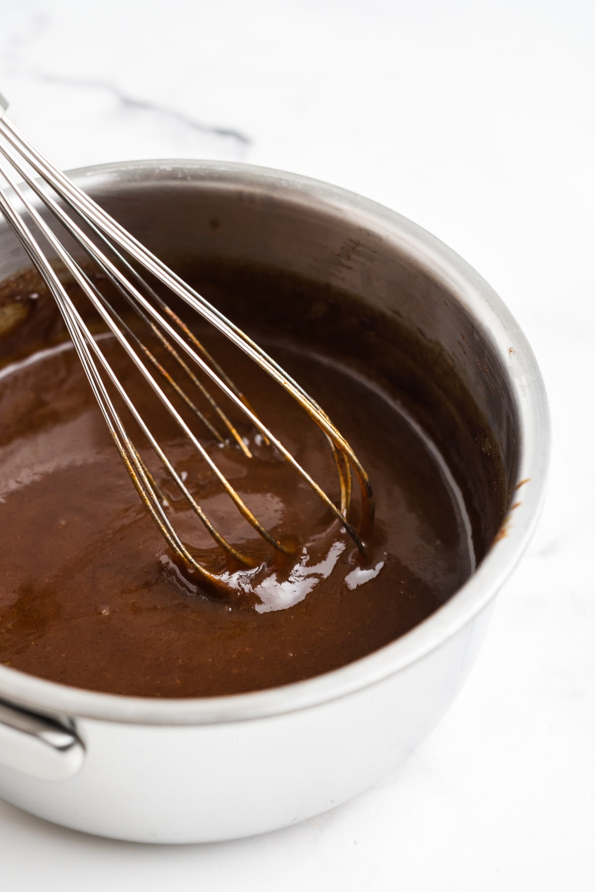 A close up image of pumpkin spice syrup being whisked. 