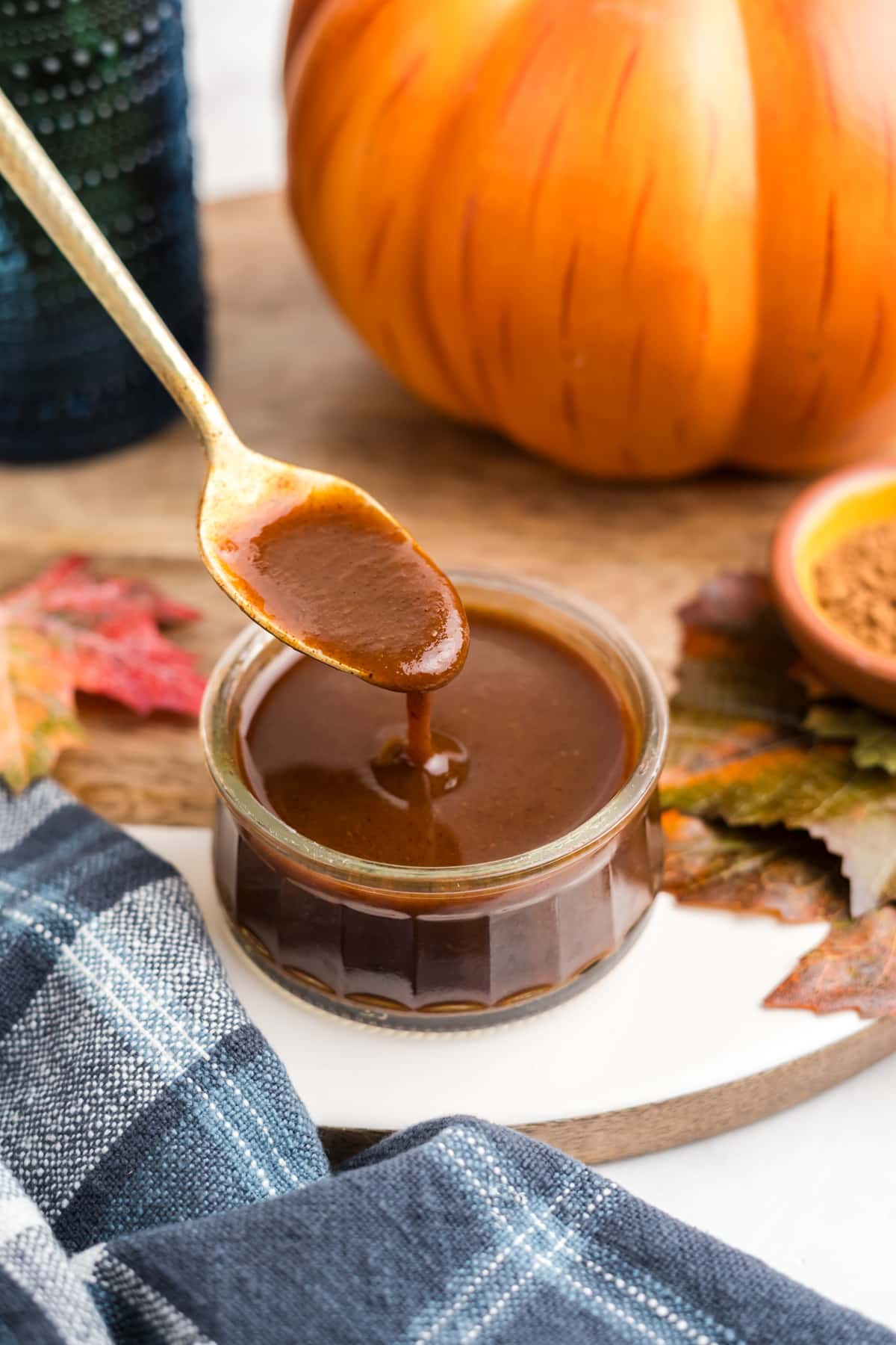 Pumpkin Spice Syrup in a jar being drizzled with a spoon. 