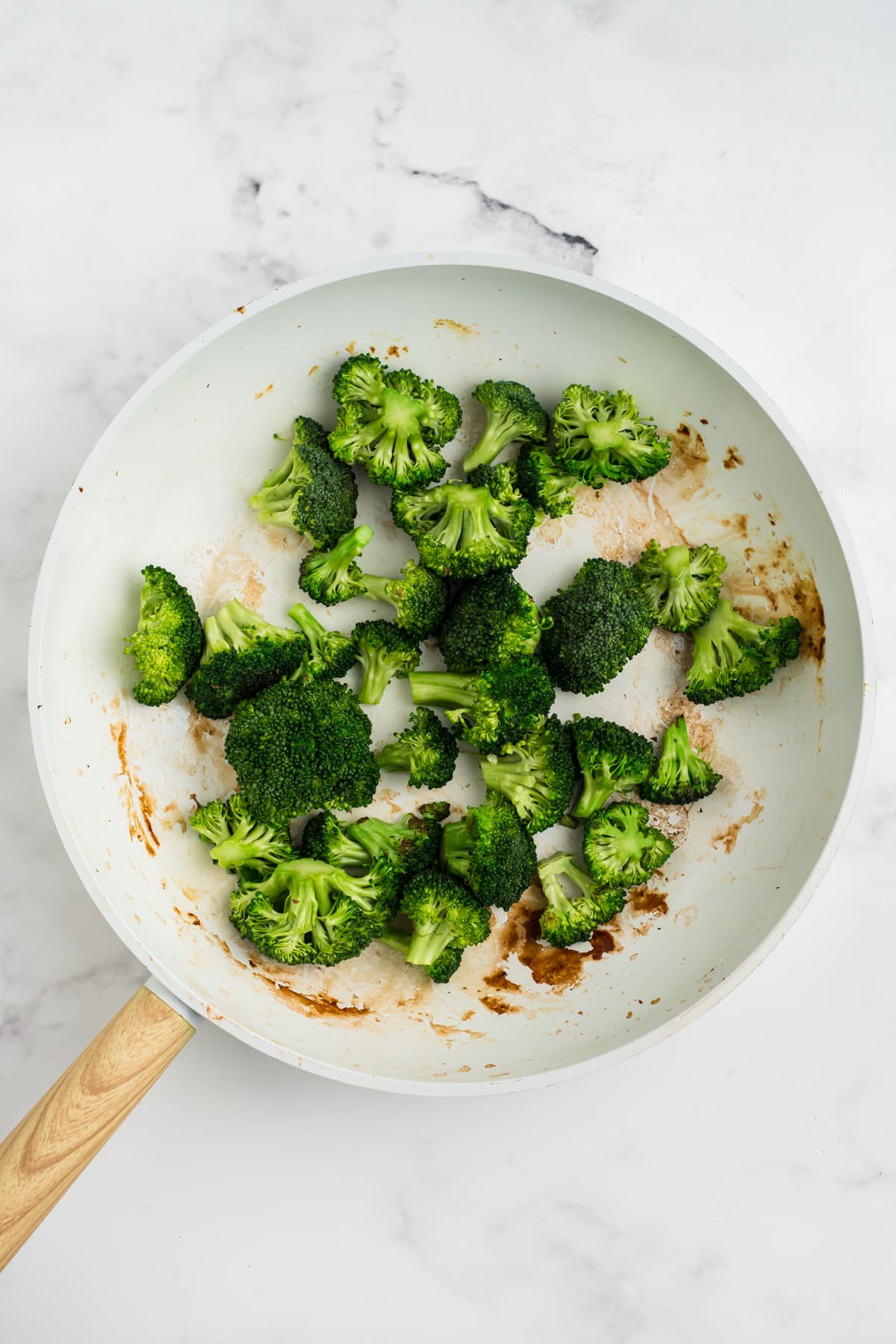 Broccoli being cooked in a skillet.