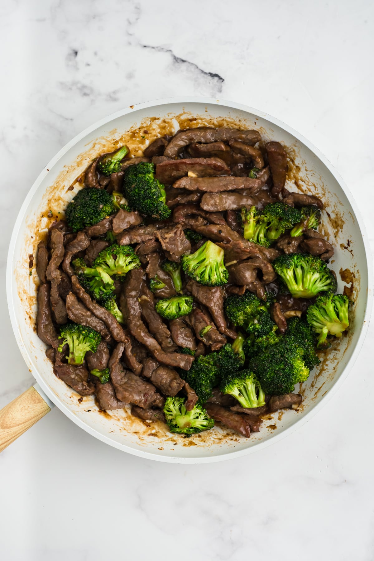 Cooked beef and broccoli in a skillet.