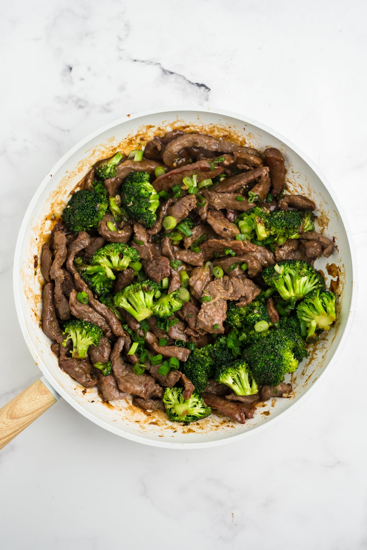 Cooked beef and broccoli with garlic sauce in a skillet.