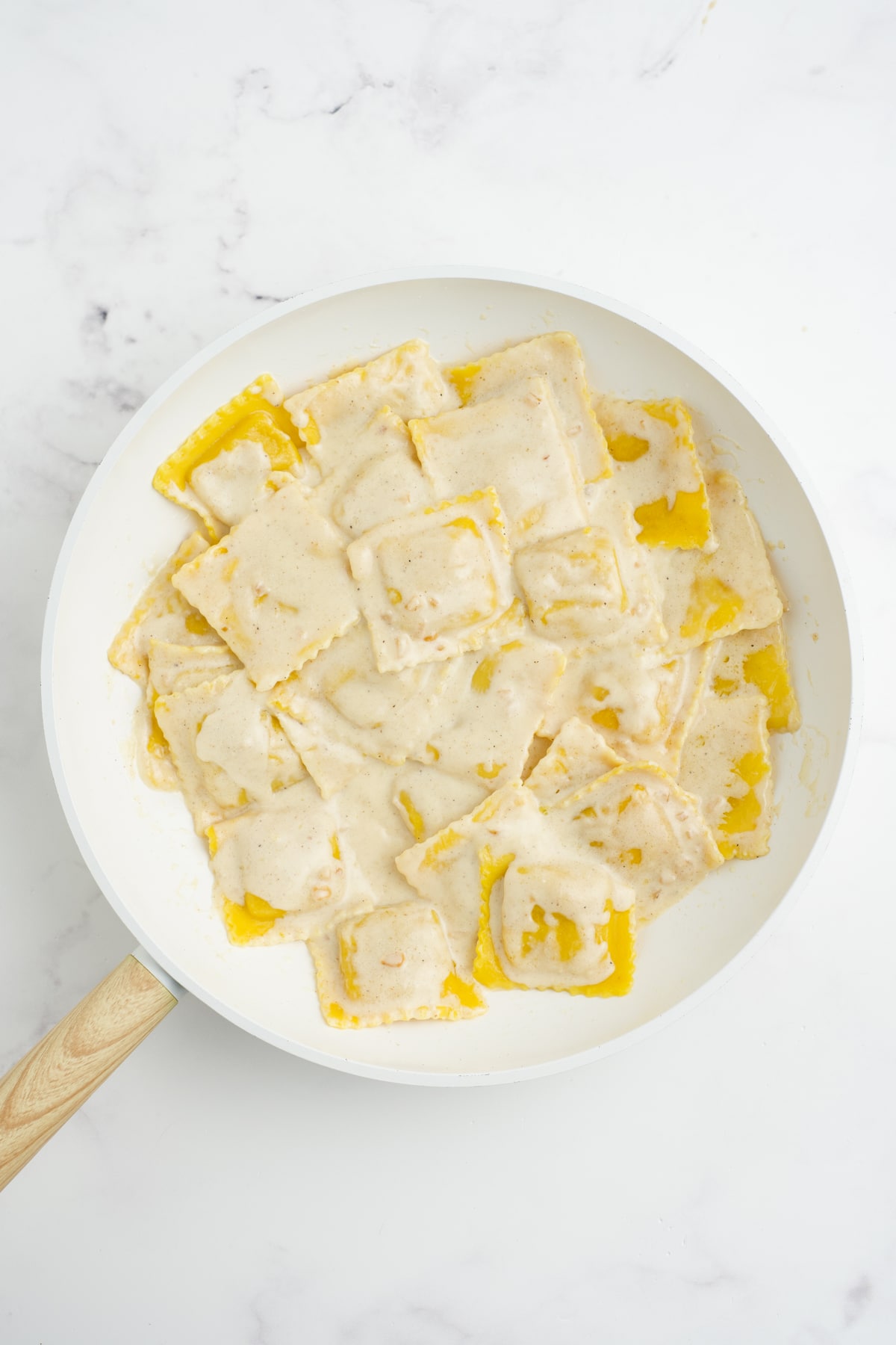 Cooked ravioli with butternut squash sauce in the pan.