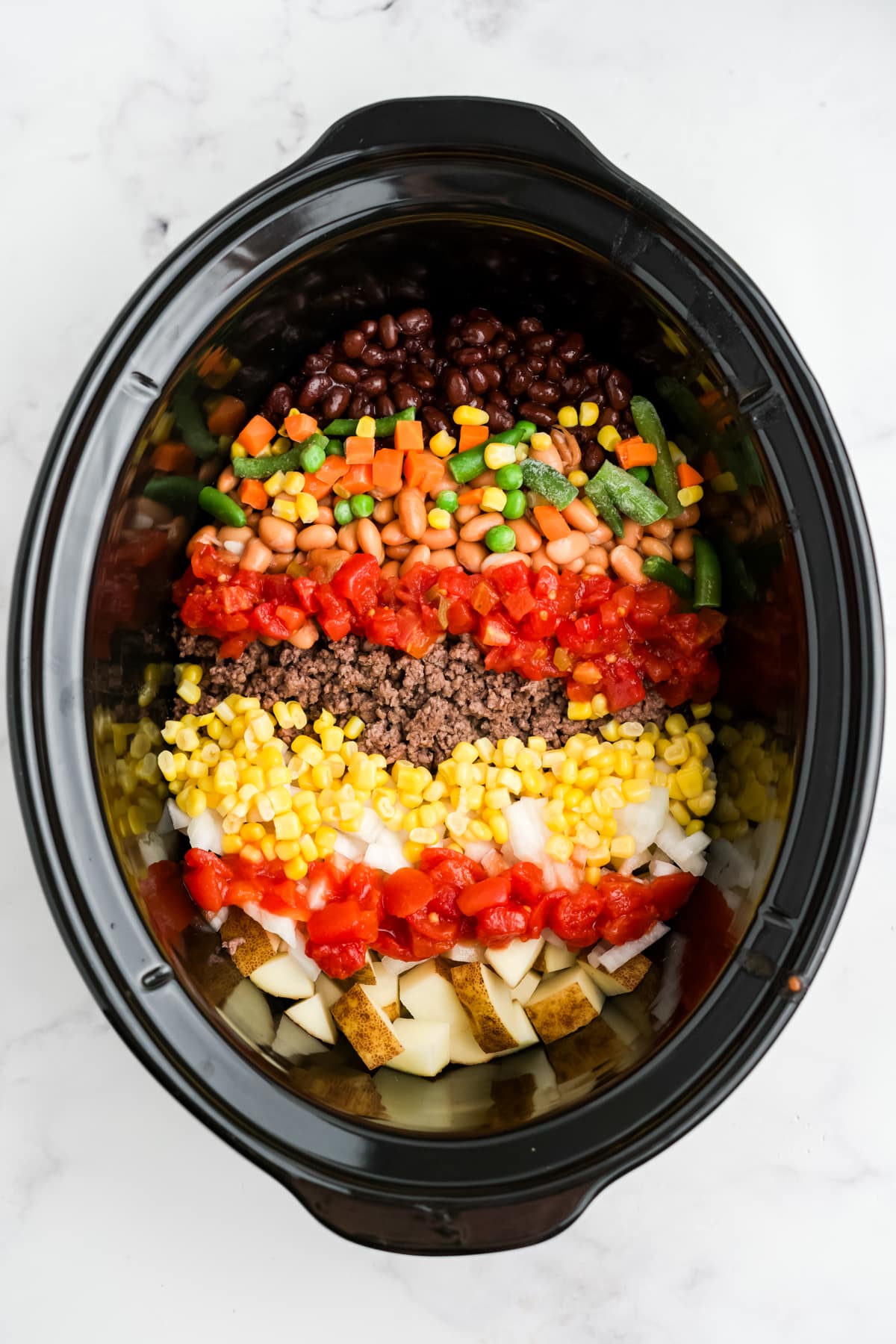 Ingredients for making crock pot cowboy soup in a slow cooker.
