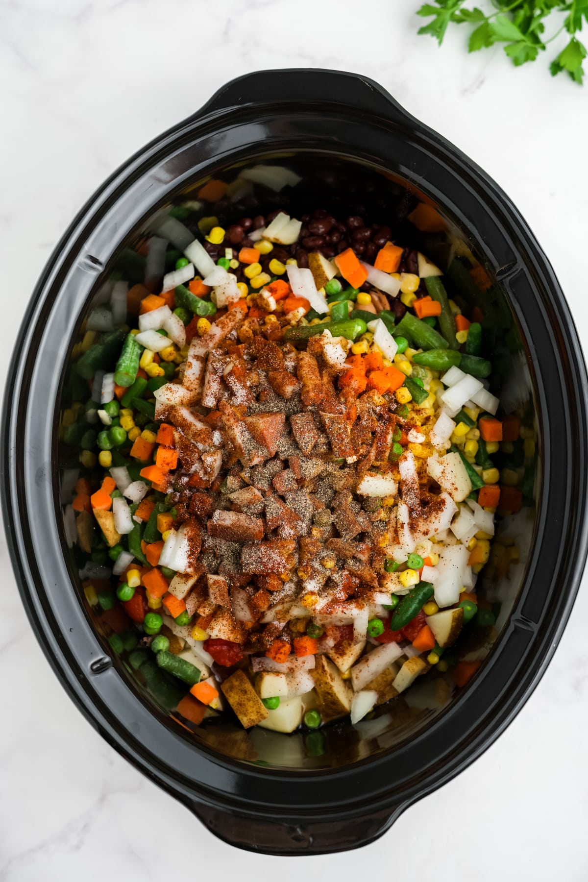 Sauce and seasonings added to the slow cooker.
