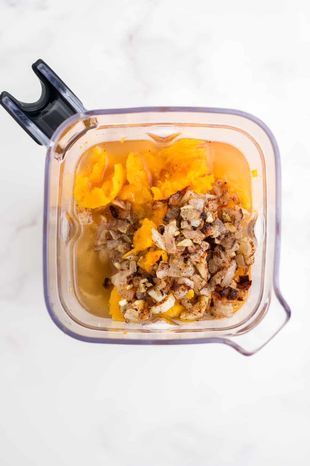 Ingredients for butternut squash soup in a blender.