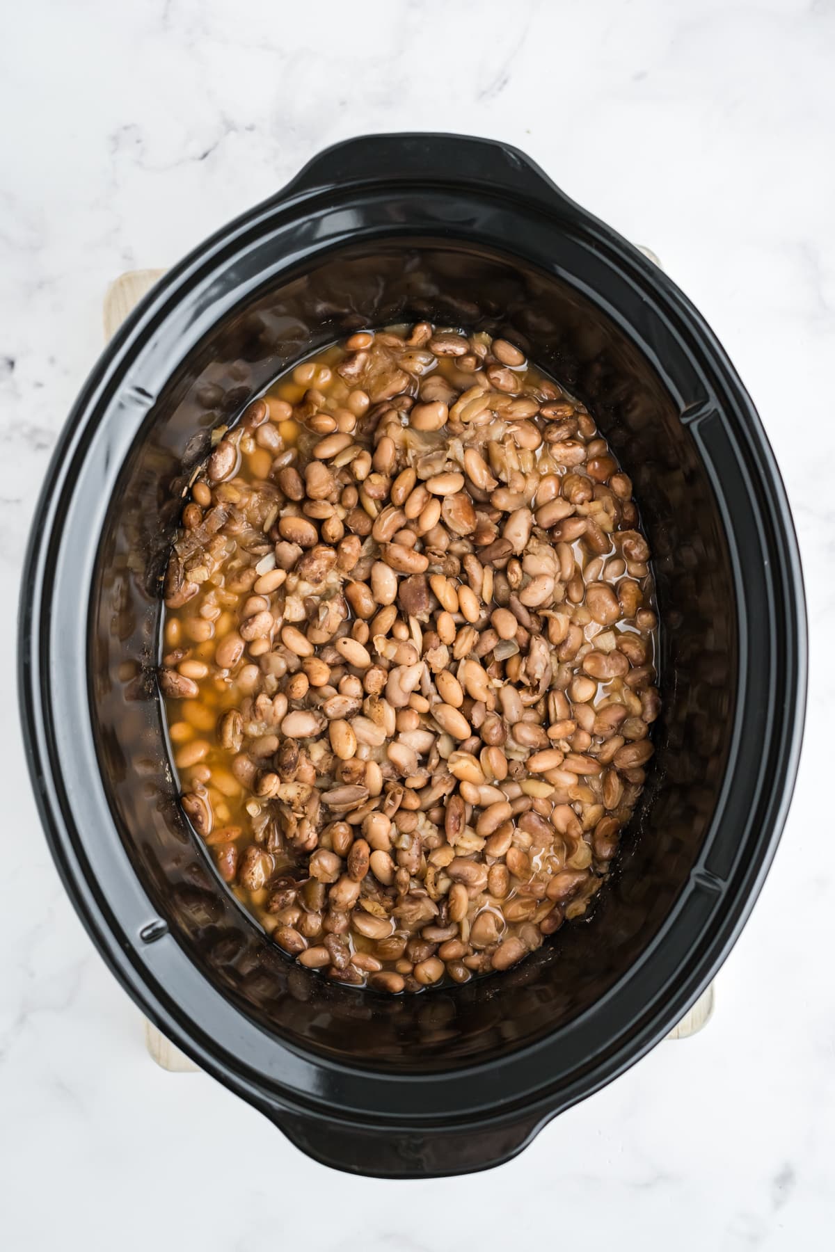 Cooked pinto beans in the crock pot.