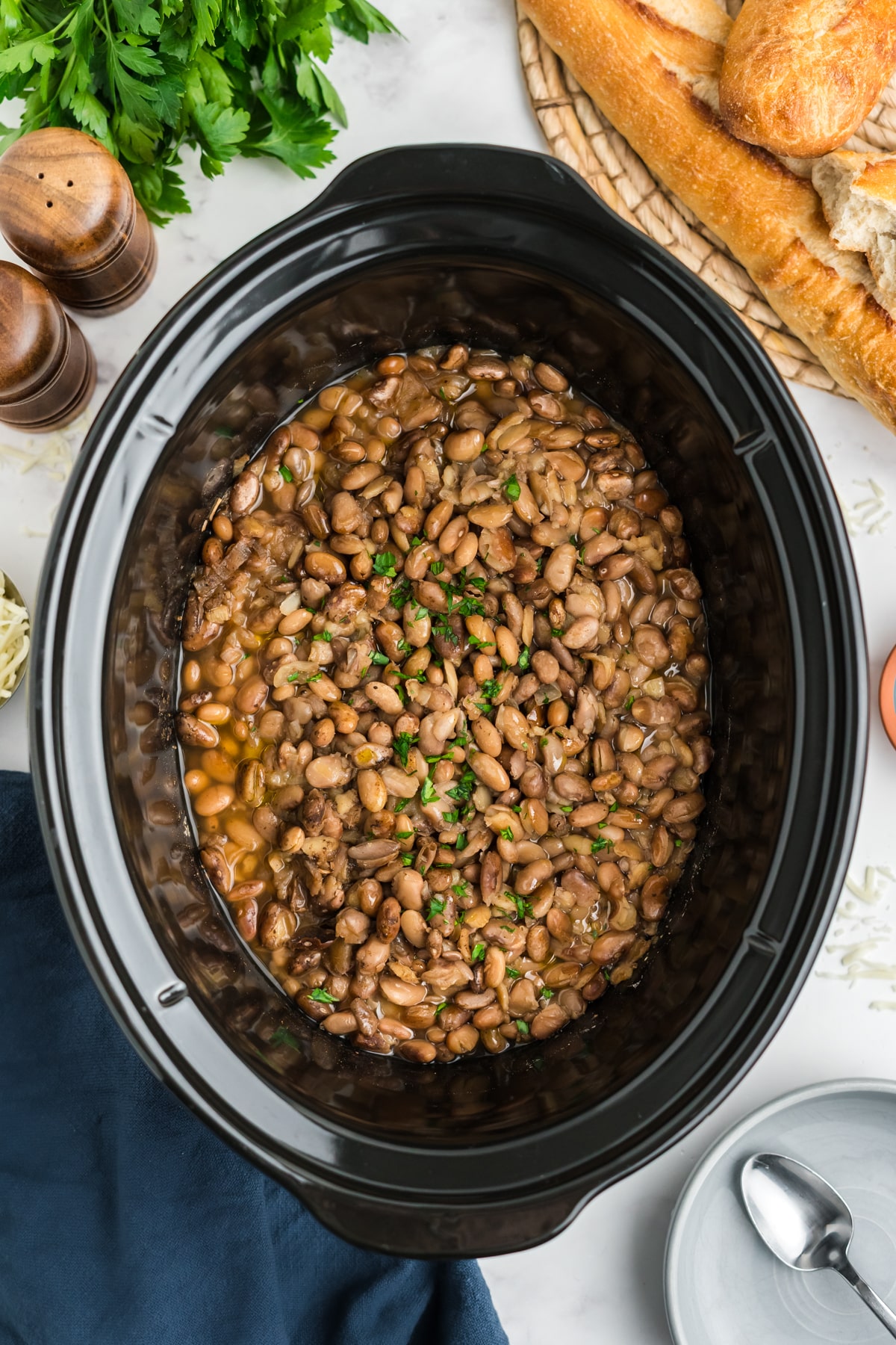 PInto beans cooked in a slow cooker garnished with parsley.