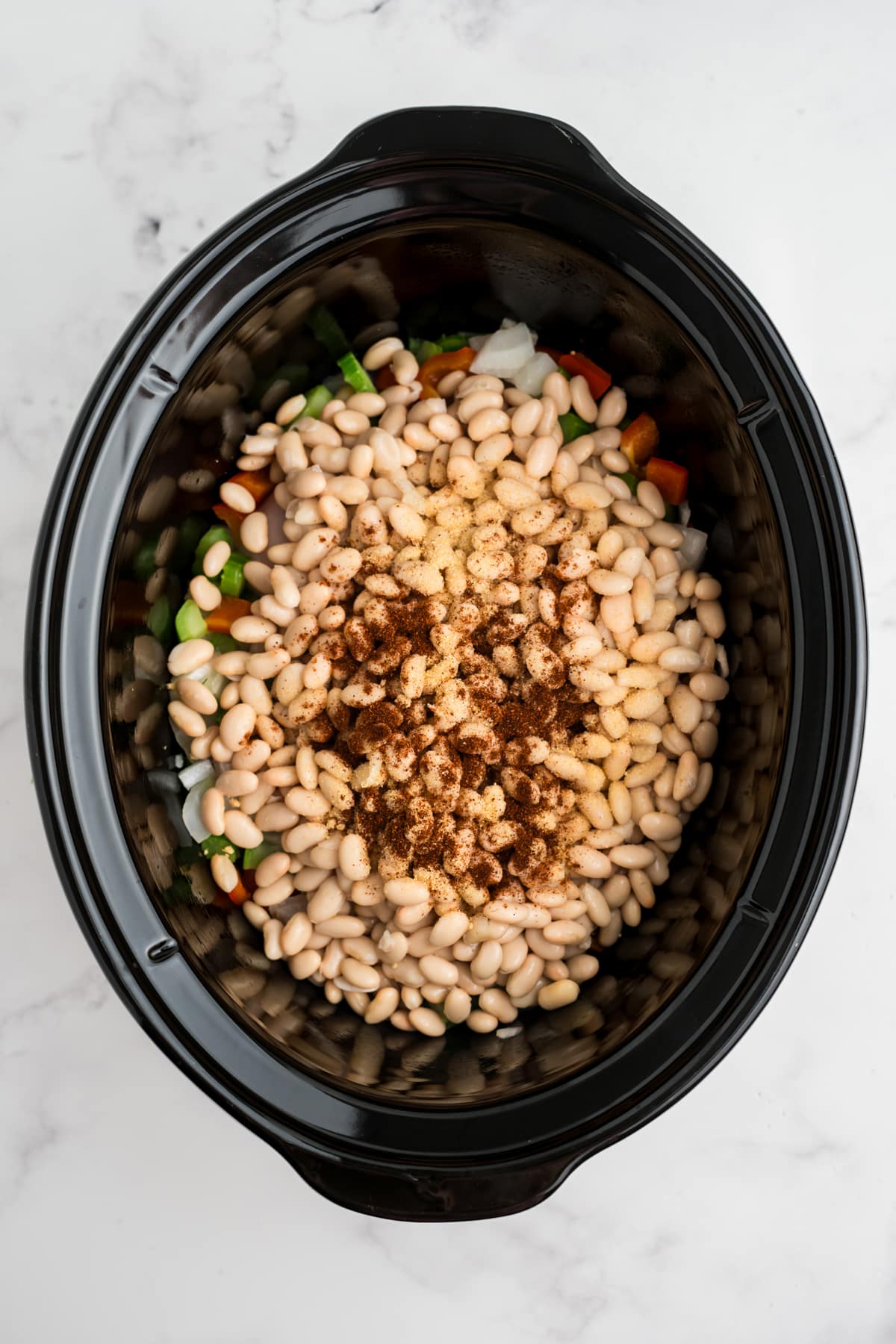 Beans and seasonings added to the slow cooker.