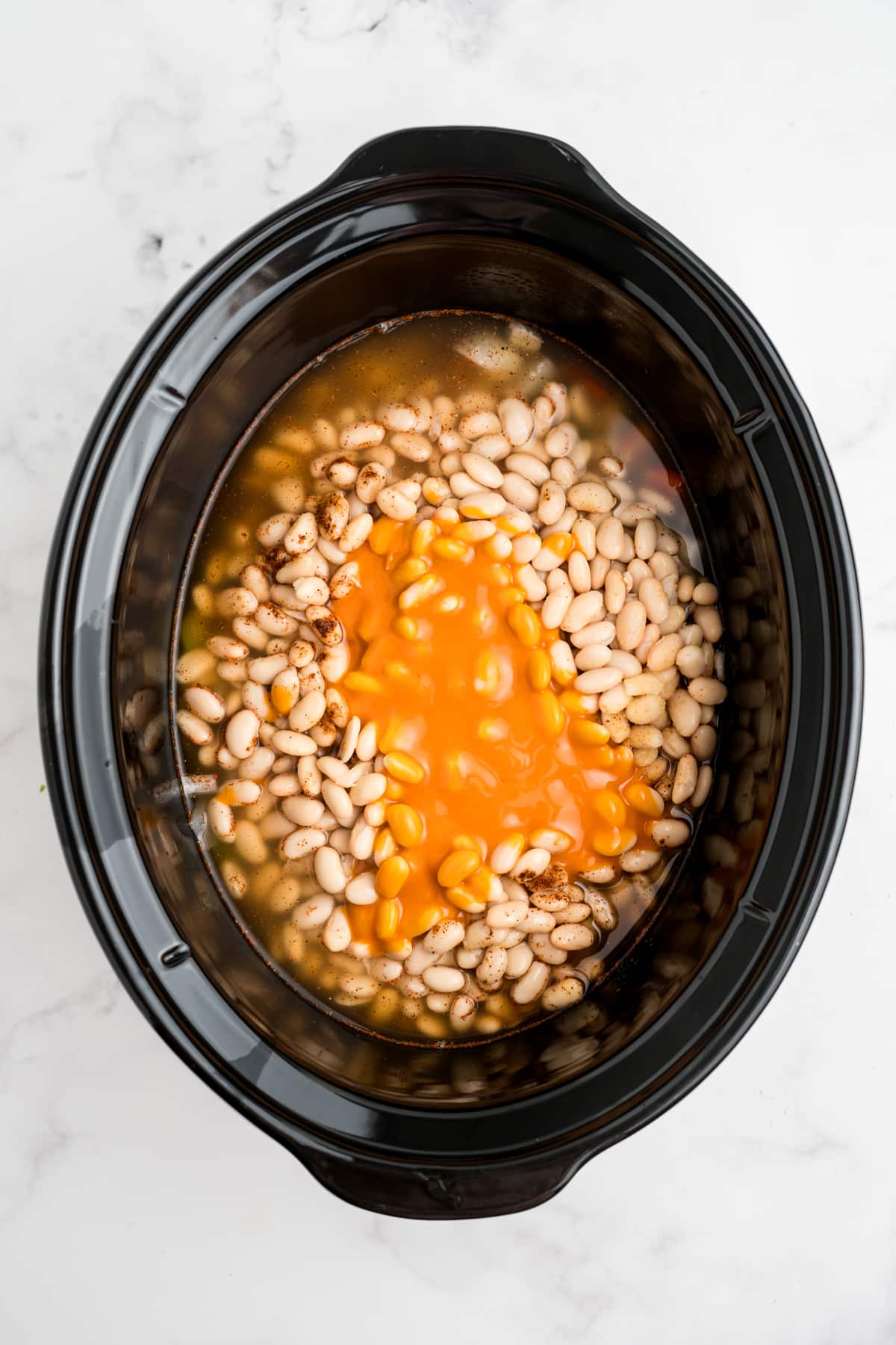 Buffalo sauce and broth added to the slow cooker.