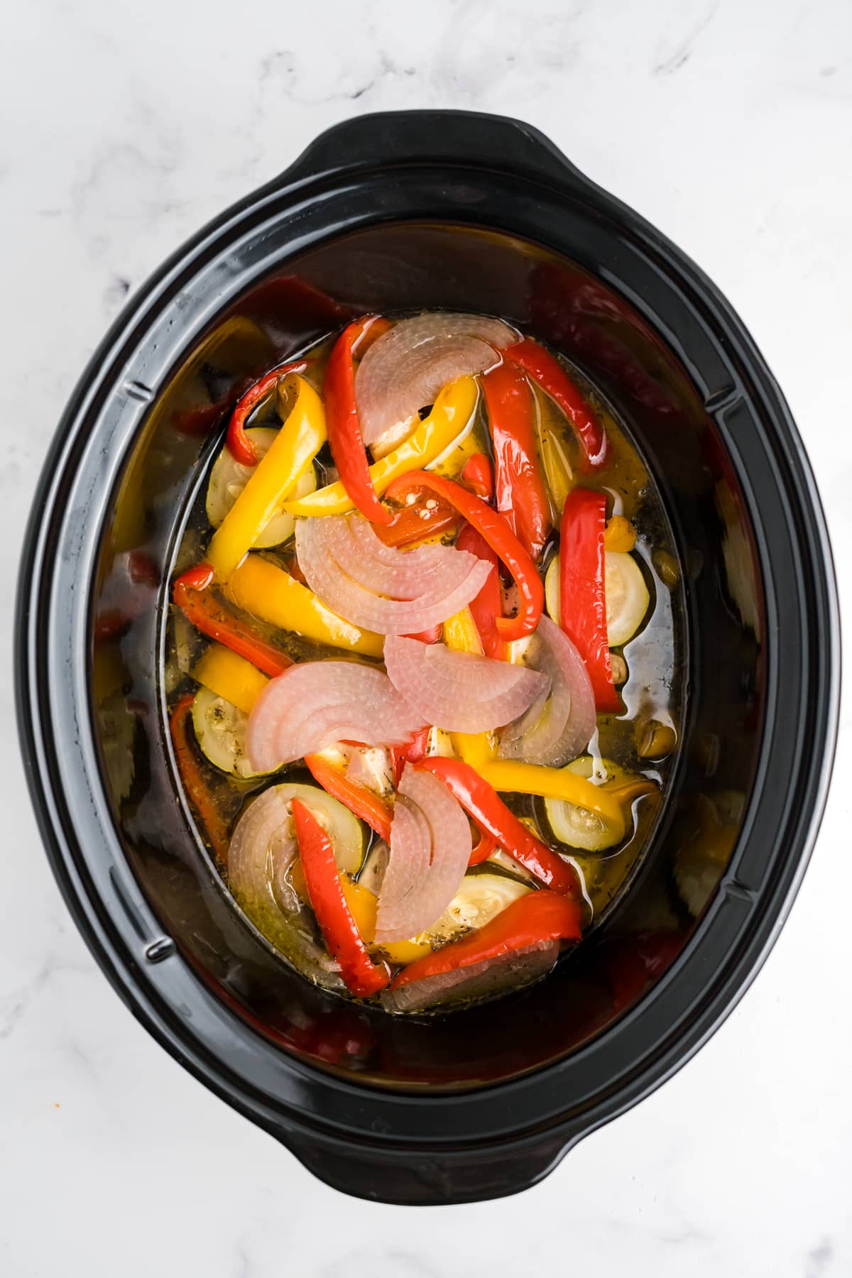 Chicken, veggies and broth in the slow cooker.