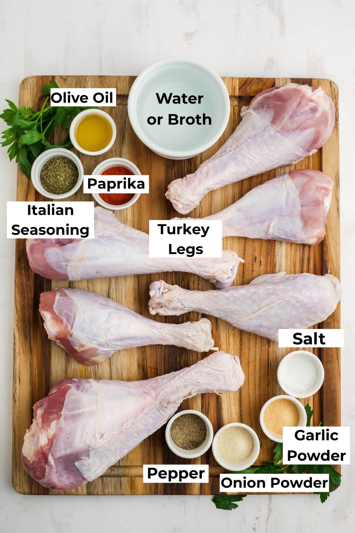 Ingredients for making turkey legs on a wooden cutting board.
