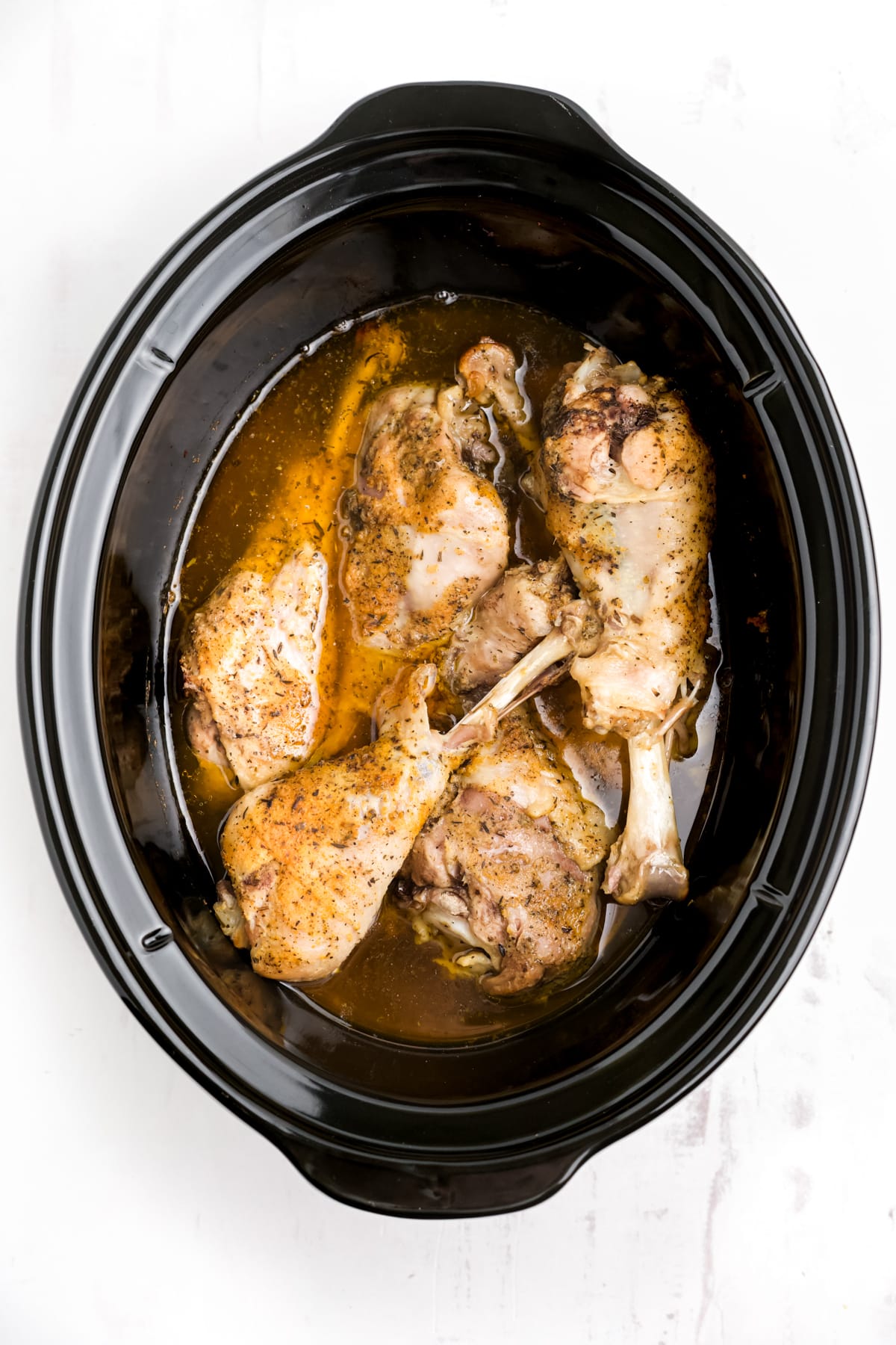 Cooked seasoned turkey legs in the slow cooker.