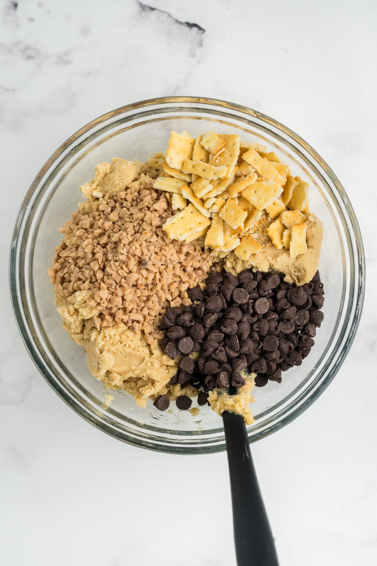 Toffee chips, chocolate chips, and saltine crackers are added to the cookie dough. 