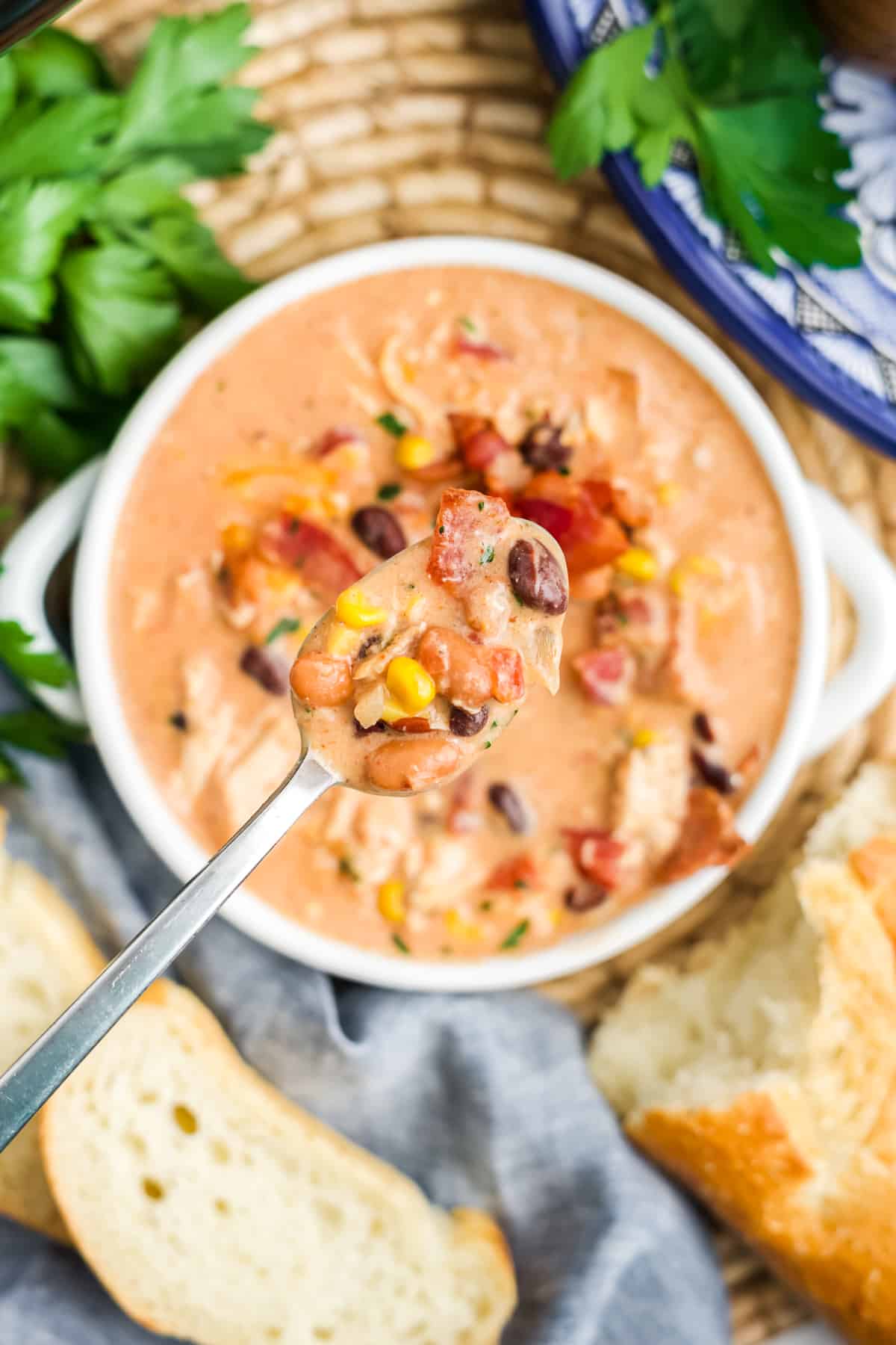 Crack chicken chili in a bowl with a spoonful held up above the bowl. 