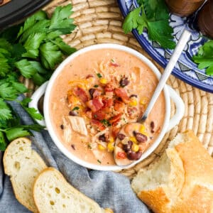 Crack chicken chili in a white bowl with a spoon resting in the chili.