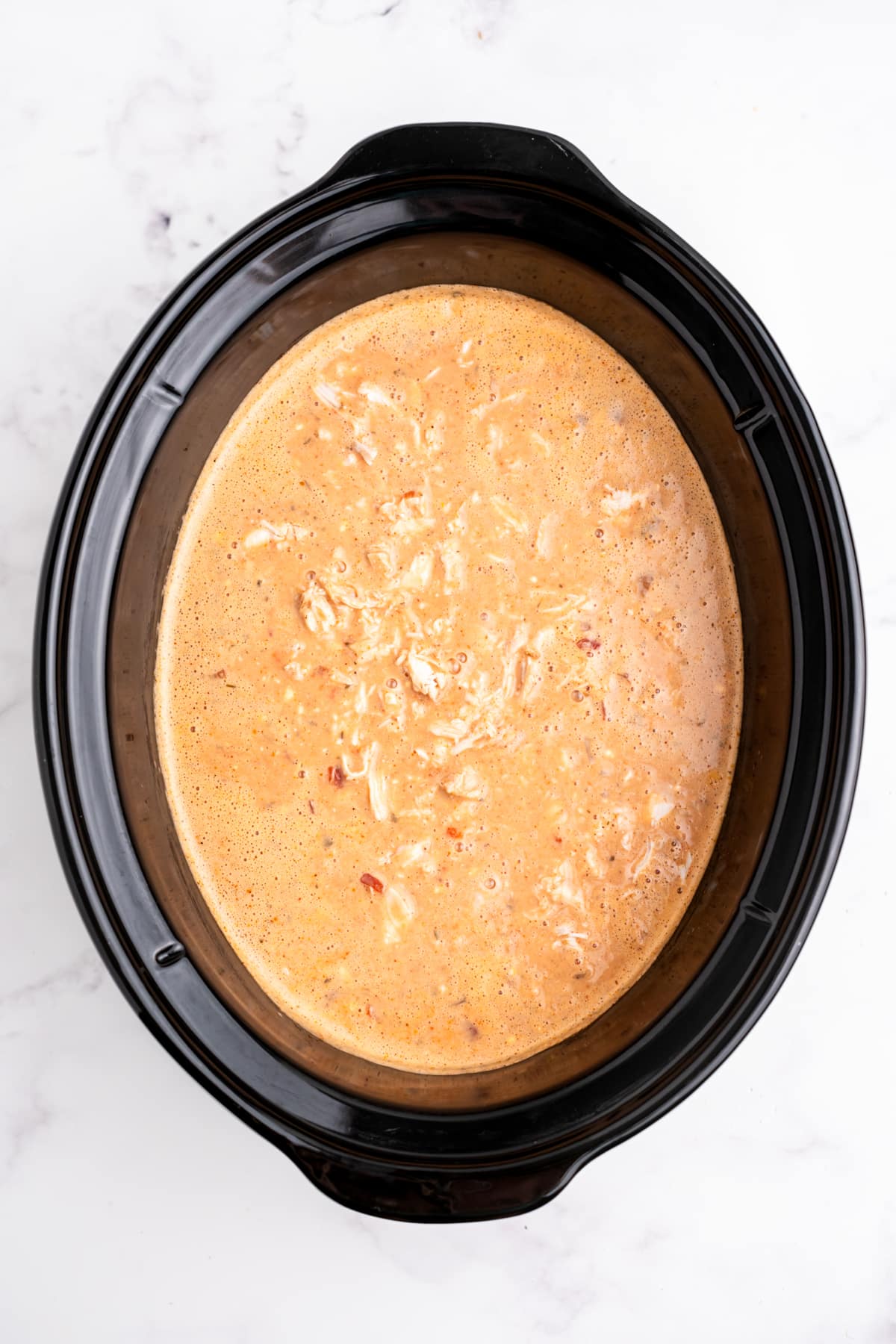 The chili mixture fully mixed in the slow cooker.