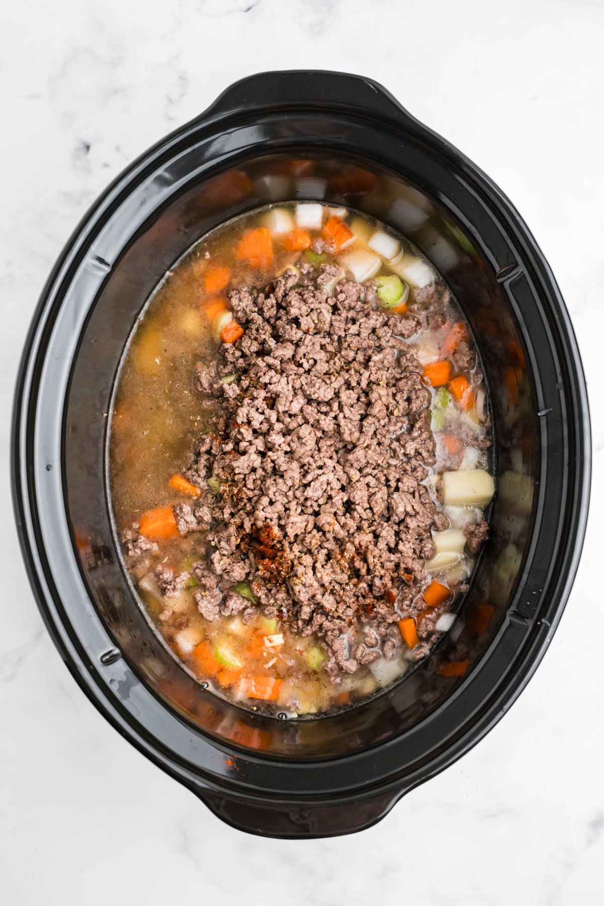 Beef broth added to the slow cooker.