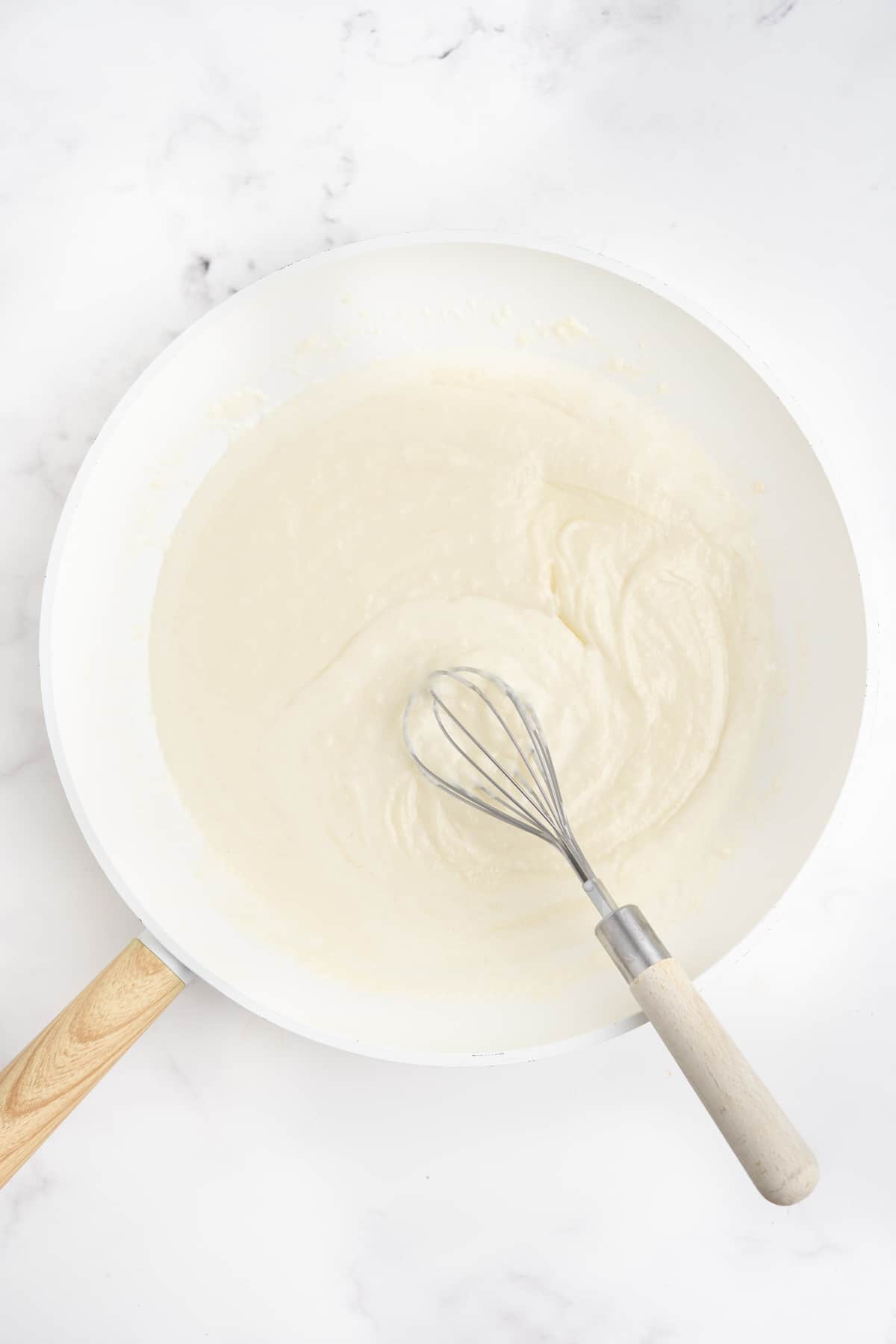 Cream sauce being made in a skillet.