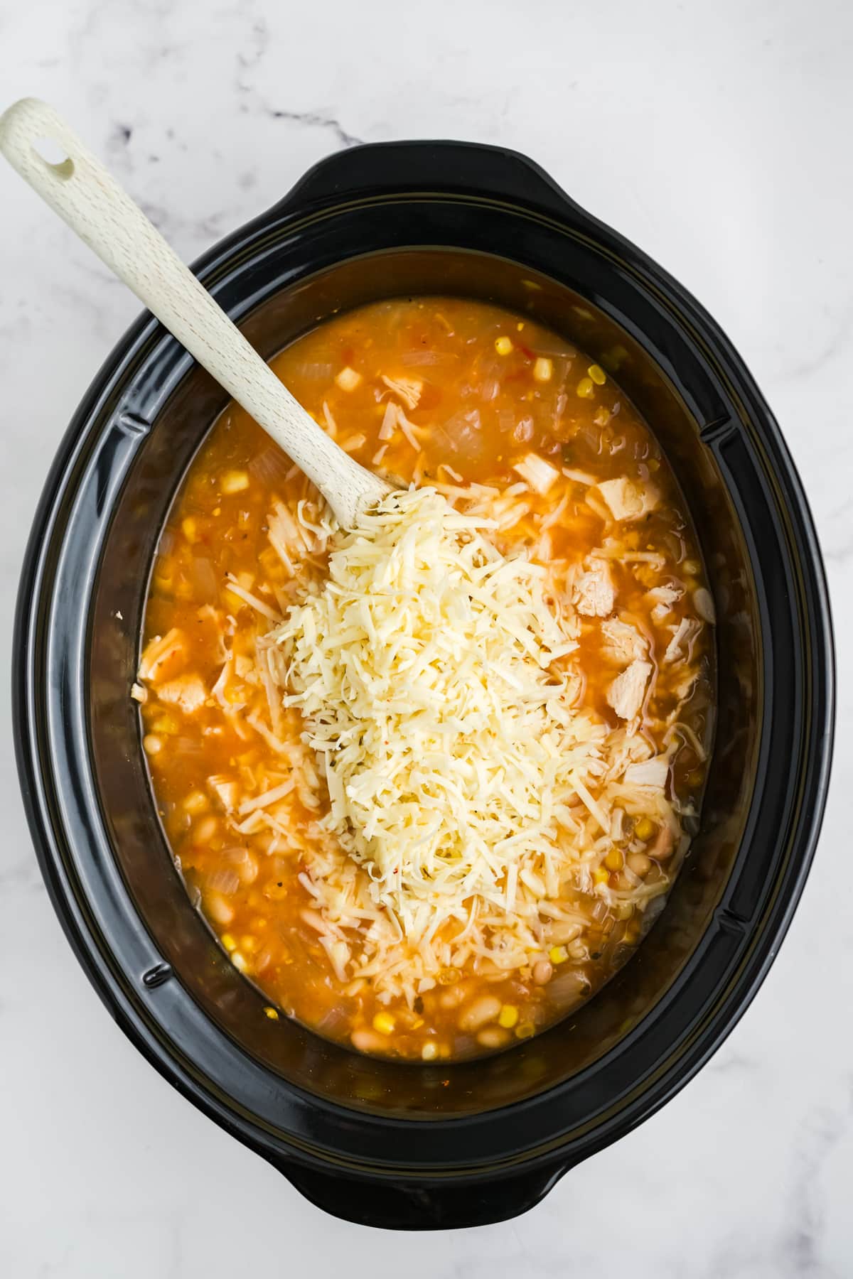 Shredded cheese added to the slow cooker.