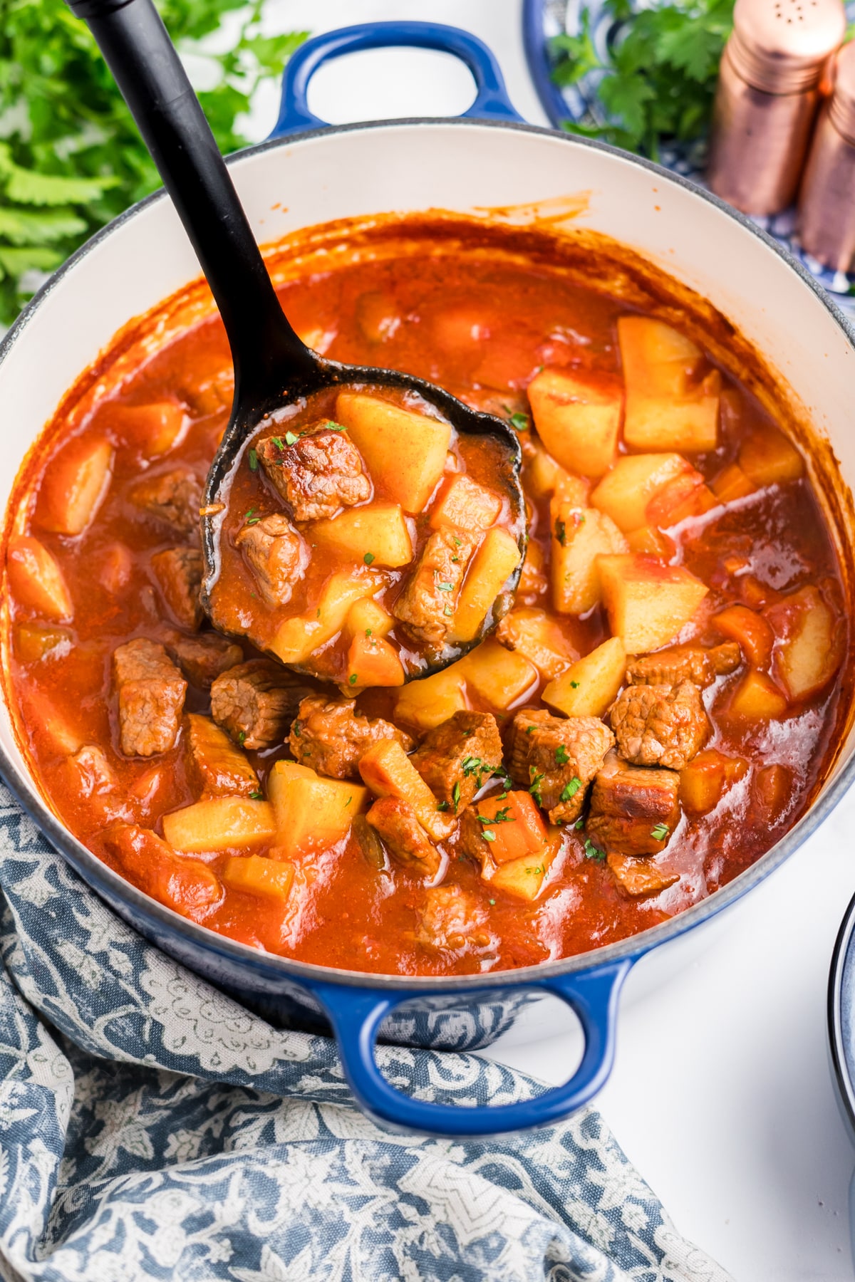 Cooked Hawaiian beef stew being ladled out of a pot.