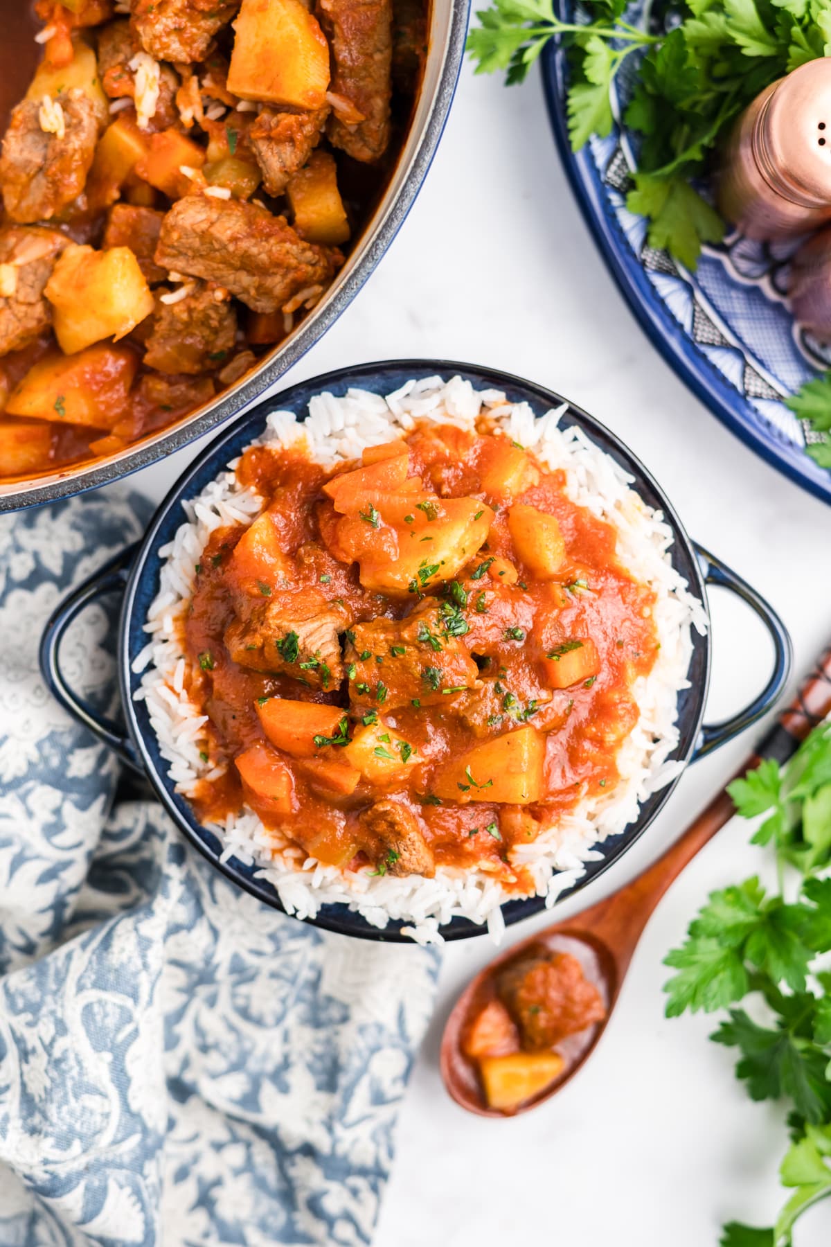 Hawaiian beef stew in a bowl on a countertop with a spoonful resting to the side. 