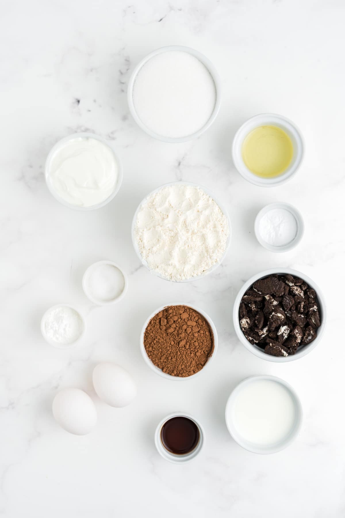 Ingredients to make Oreo muffins on a table in bowls.