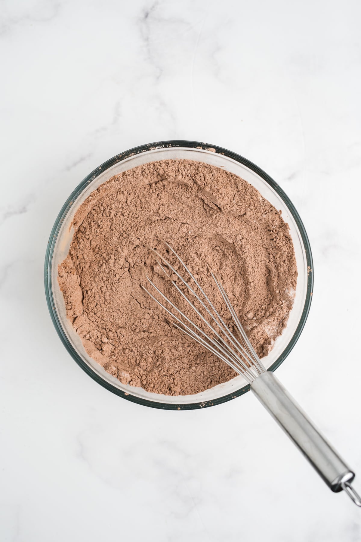 Dry ingredients for the Oreo muffins mixed in a glass bowl.