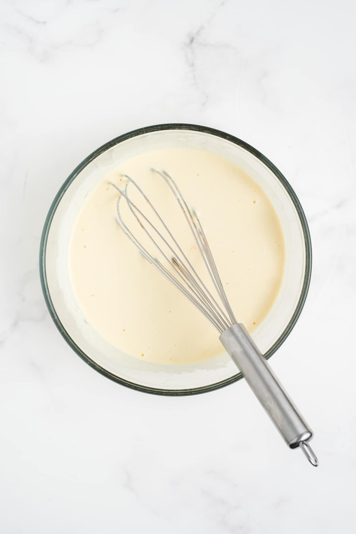 Wet ingredients for the muffins mixed in a glass bowl.