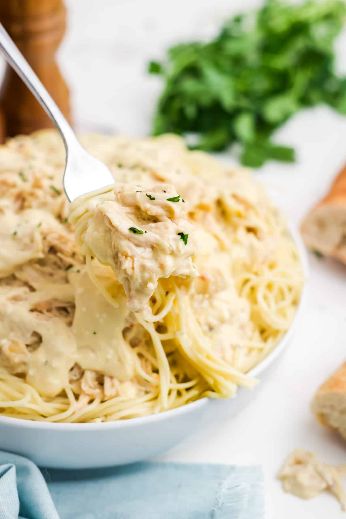A fork holding up a bite of slow cooker angel chicken. 