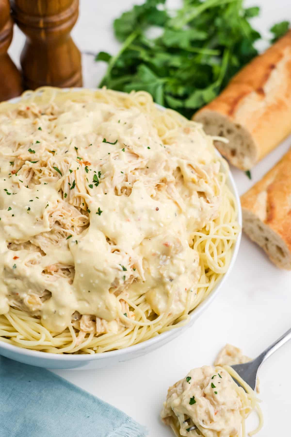 Crockpot angel chicken served up in a bowl with pasta. 