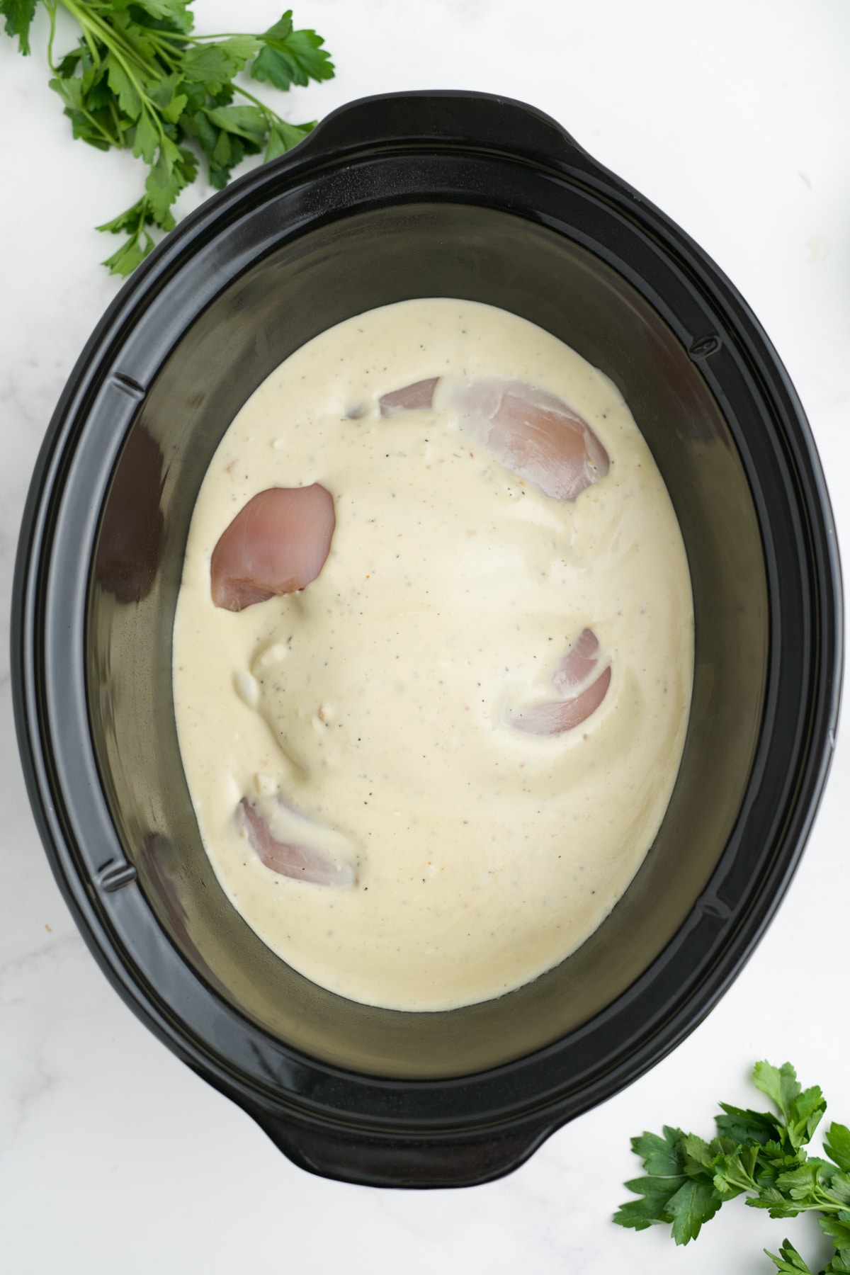 Chicken in the slow cooker with the sauce poured over the top. 