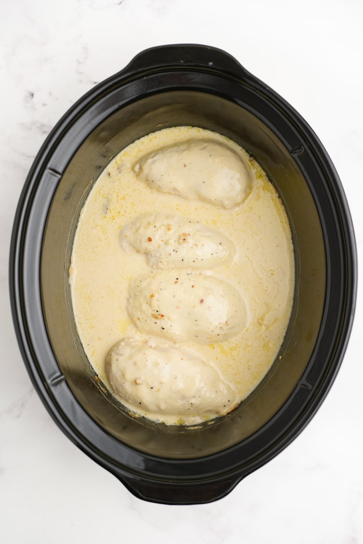 Cooked angel pasta chicken in a crockpot.