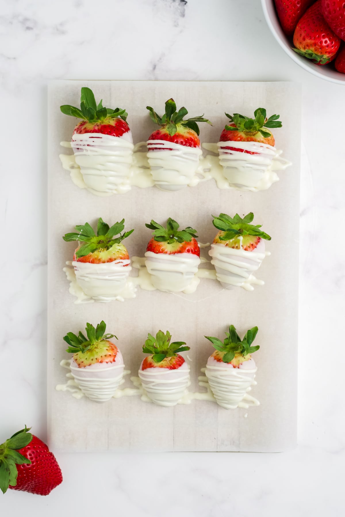 White chocolate covered strawberries after being drizzled with additional chocolate. 