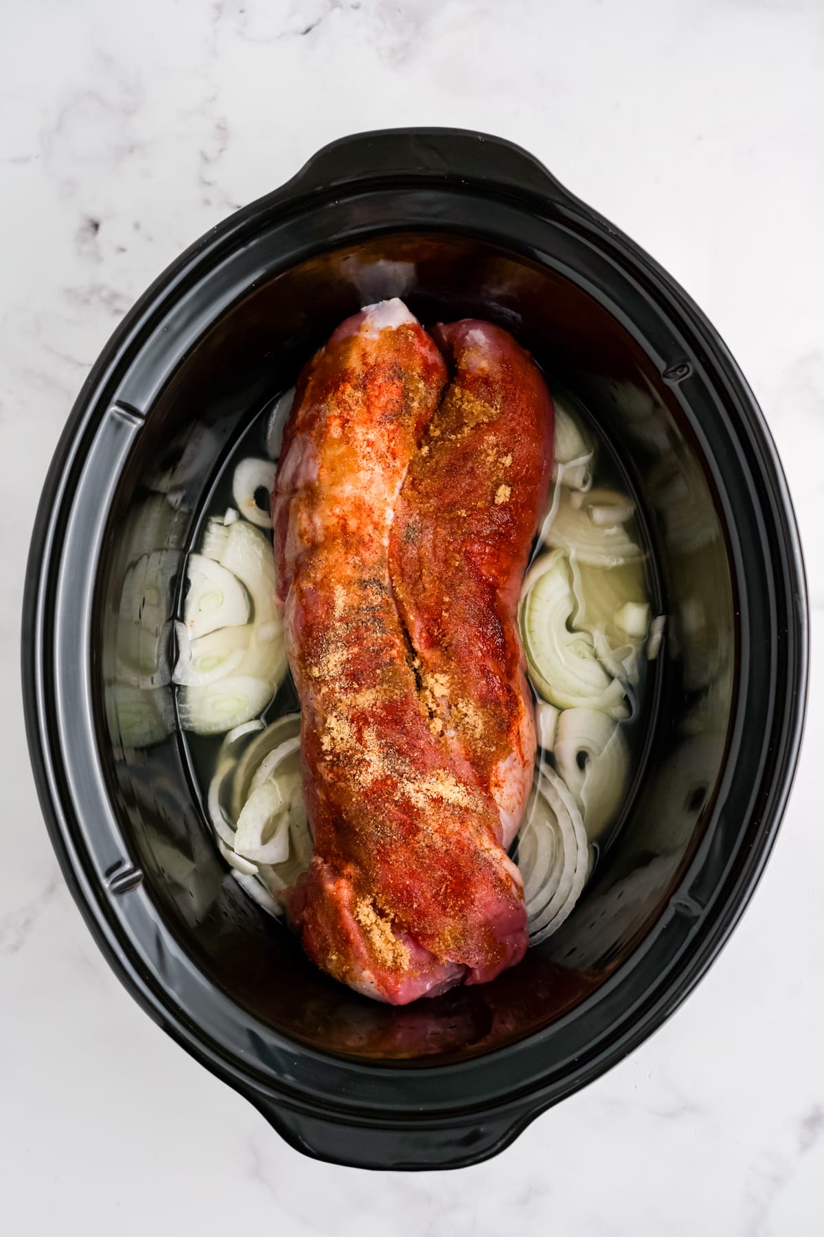 Pulled pork tenderloin ingredients in a slow cooker.