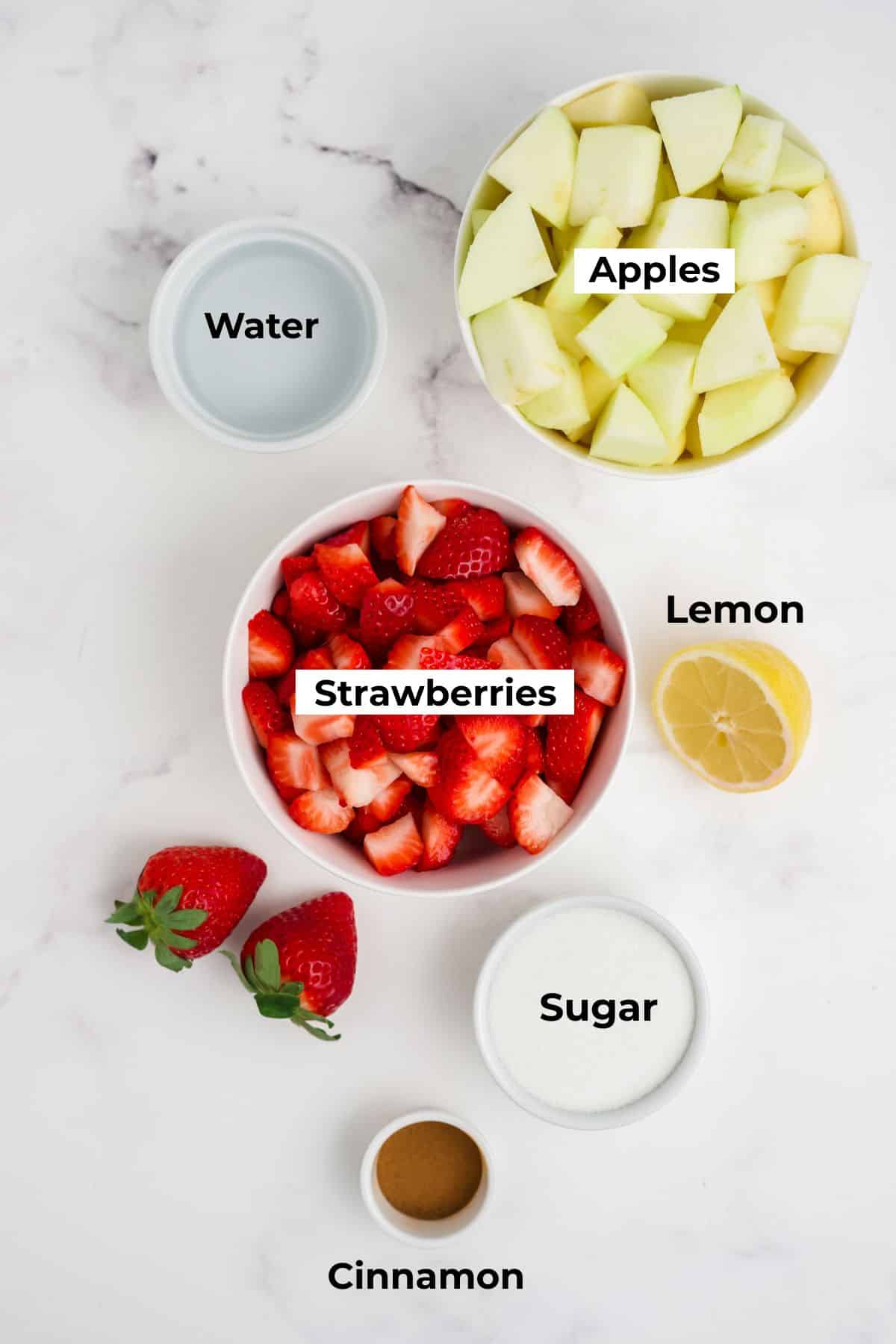 Ingredients on a table to make strawberry applesauce. 