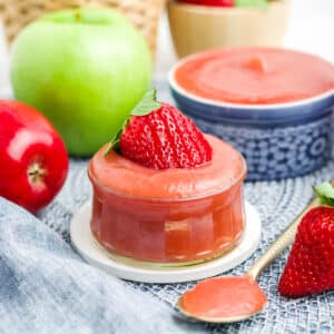 Strawberry applesauce recipe served up in a jar and a blue and white dish.