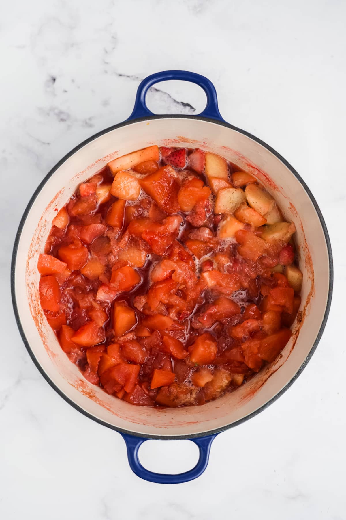 The fruit cooking in a pot.