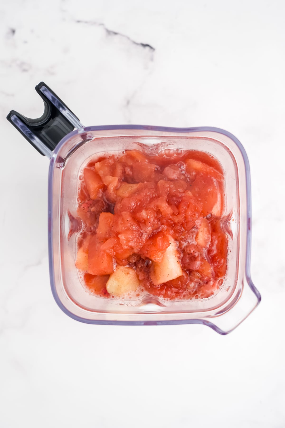 The cooked fruit added to a blender.