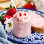 Strawberry butter in a jar with a spoon dipping into the jar.