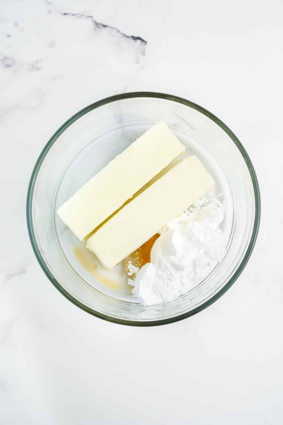 Ingredients for making strawberry butter together in a glass bowl.