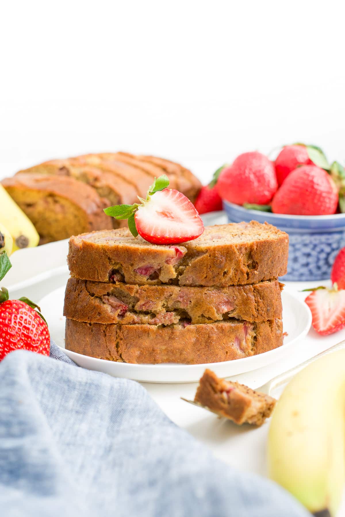 A plate with three slices of strawberry banana bread.
