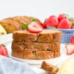 A plate of strawberry banana bread with a strawberry on top.