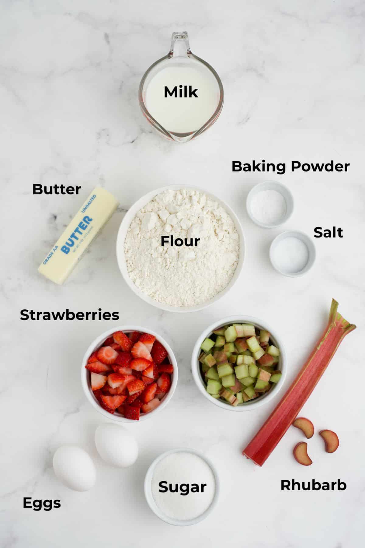 Ingredients to make strawberry rhubarb muffins in bowls.
