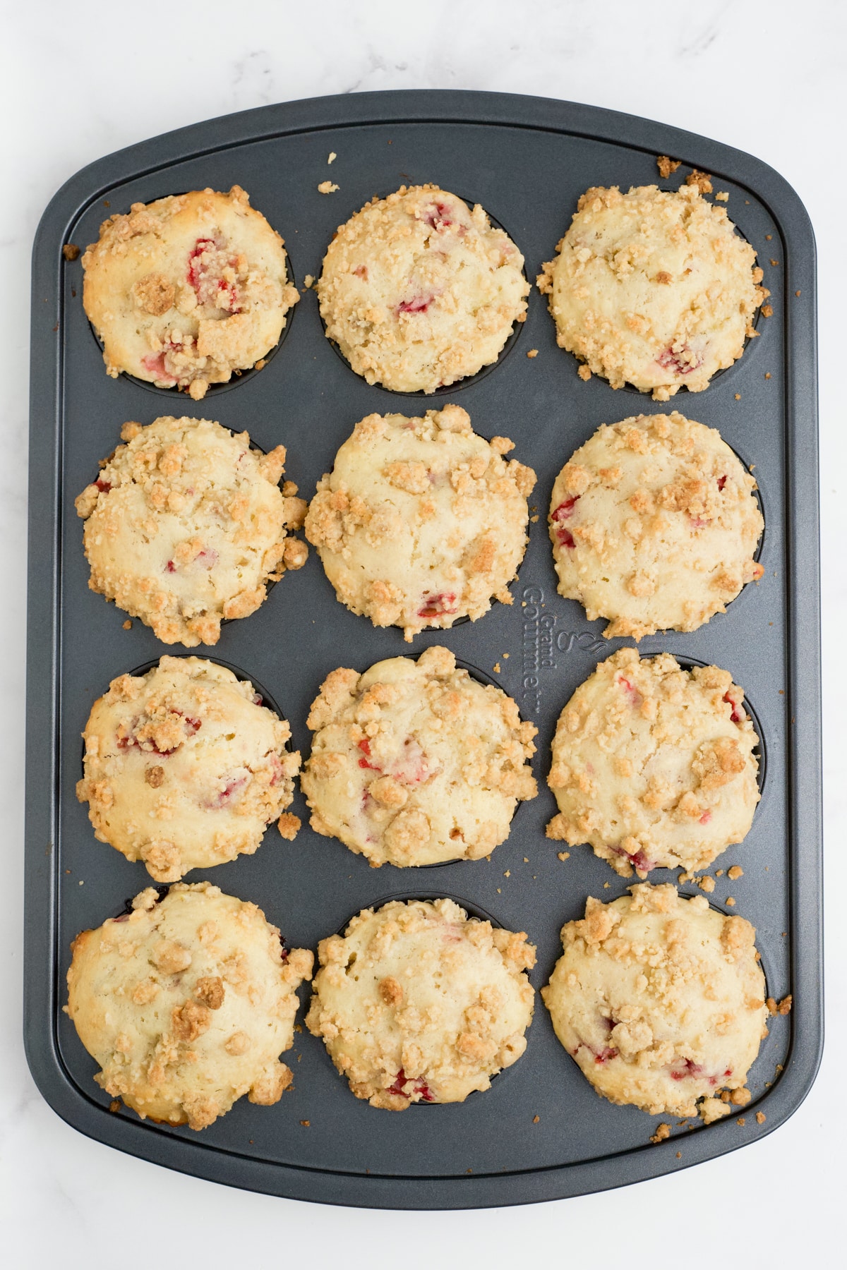 Baked strawberry rhubarb muffins in the pan.