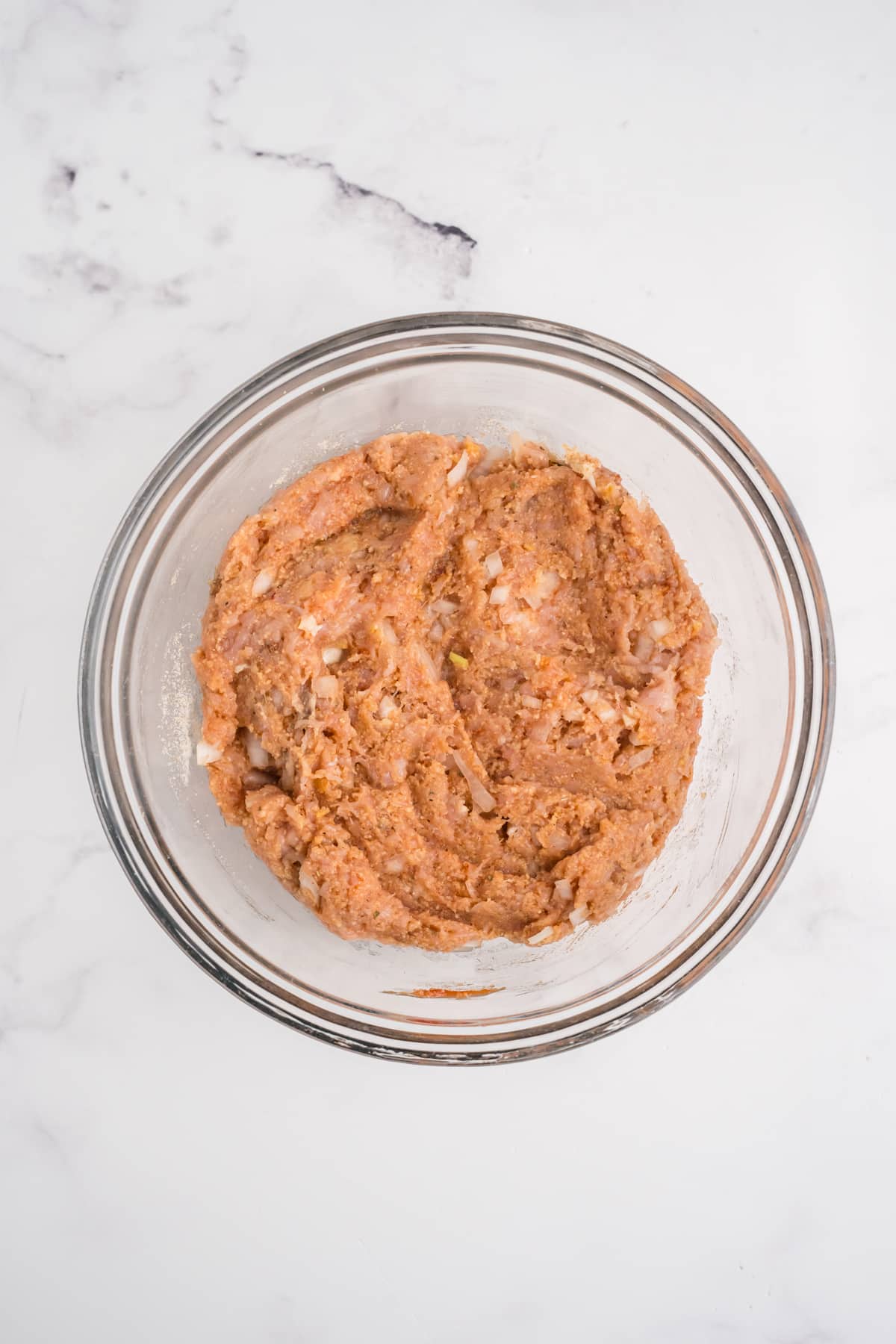 All the ground chicken meatloaf ingredients mixed in a bowl.