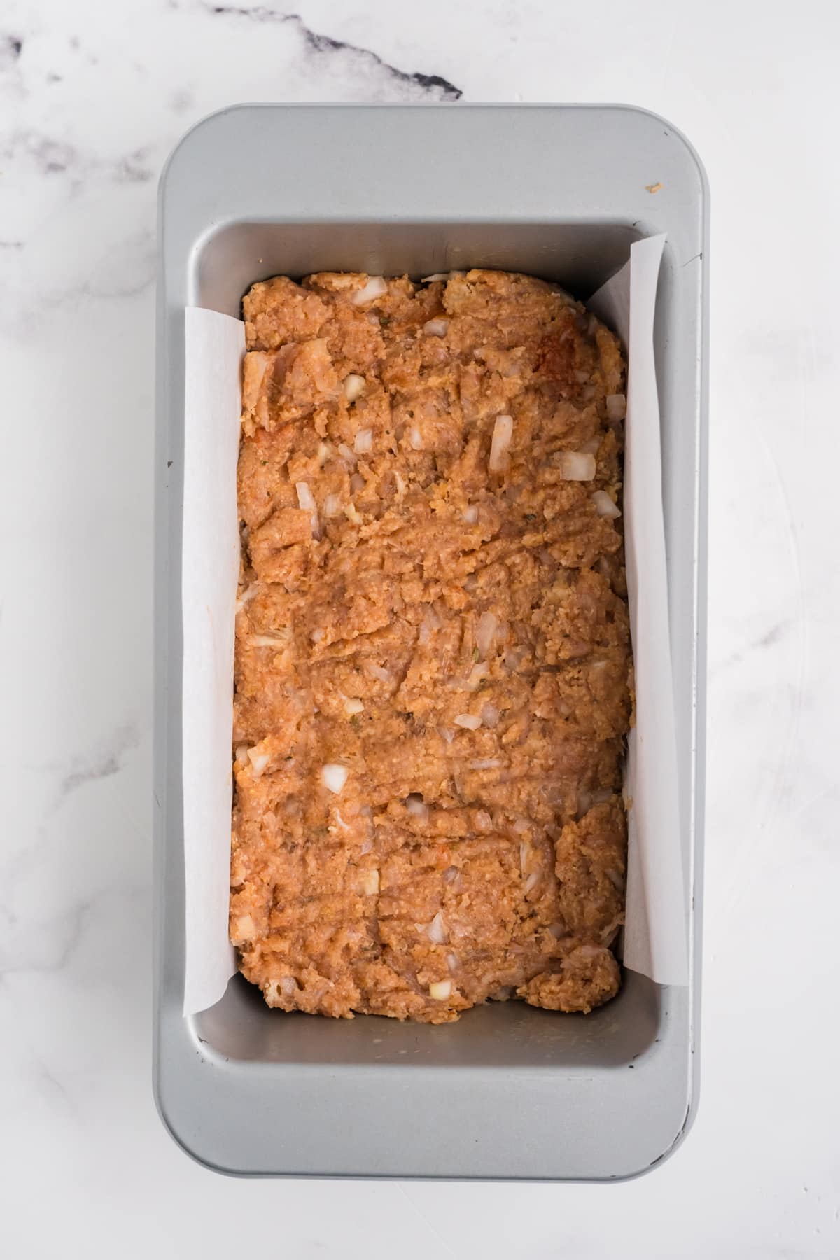 The chicken mixture added in a prepared loaf pan.