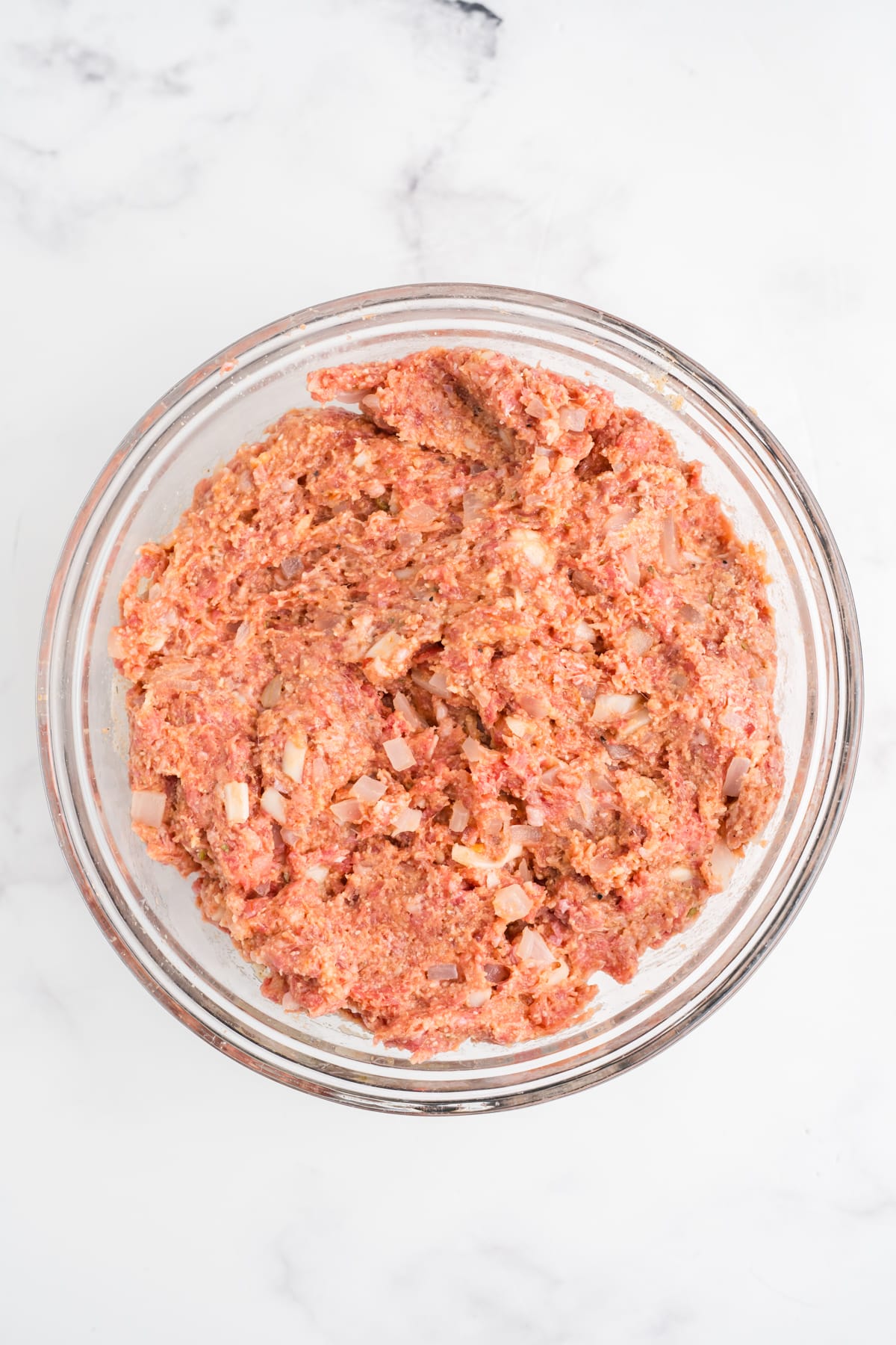 All the Italian meatloaf ingredients mixed in a bowl.